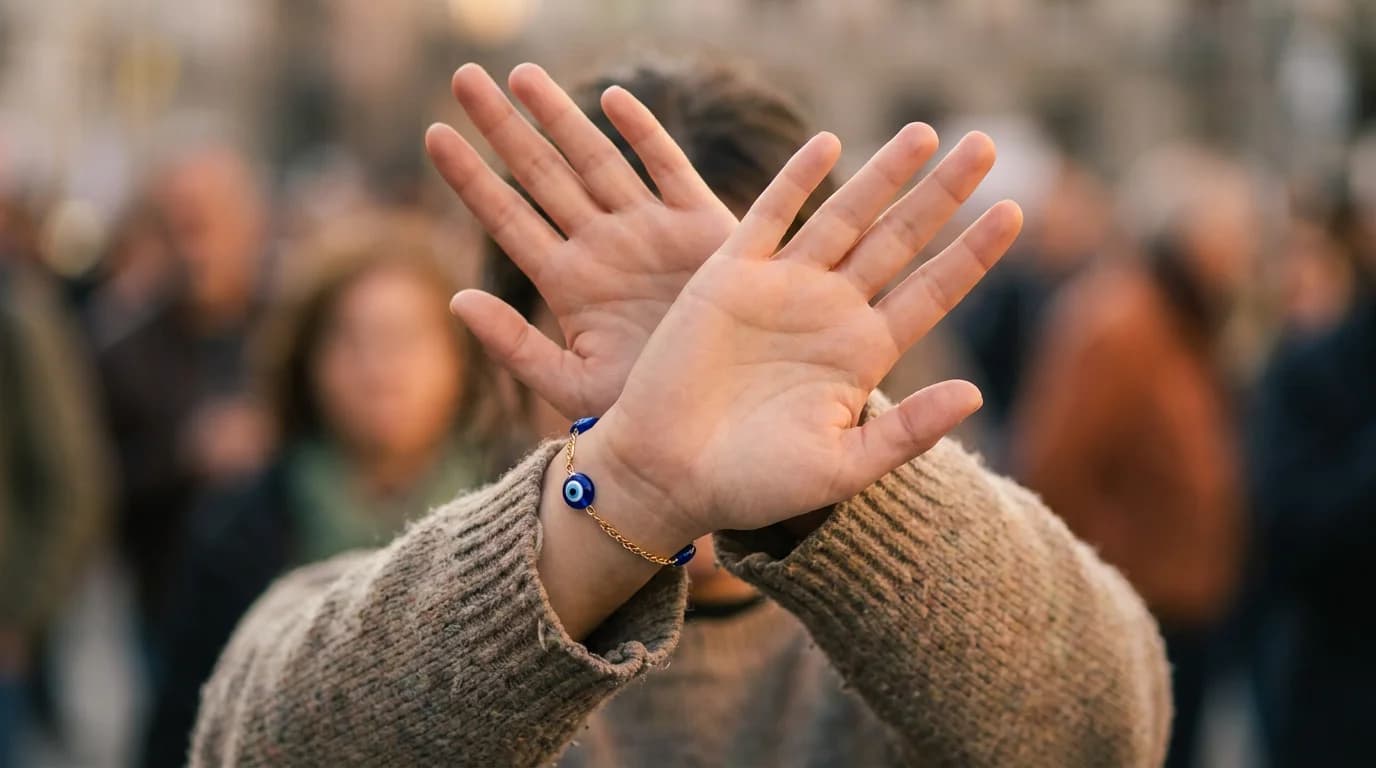 Woman wearing DivineTatva evil eye bracelet at desk, looking calm and focused — suggesting psychological comfort